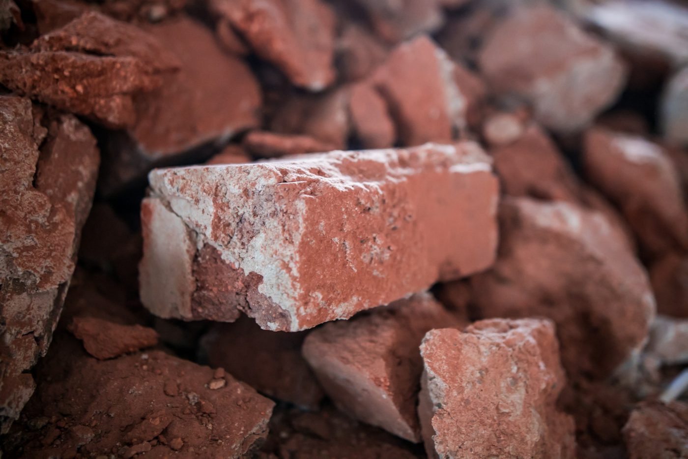 Broken brick and rubbish next to an old ruined building. Dump. Urban economy.