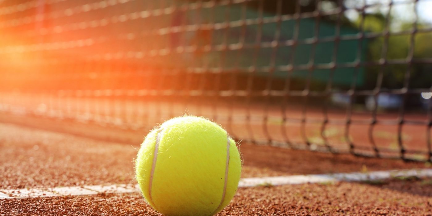Symbolic image: Tennis court with ball and net, close-up